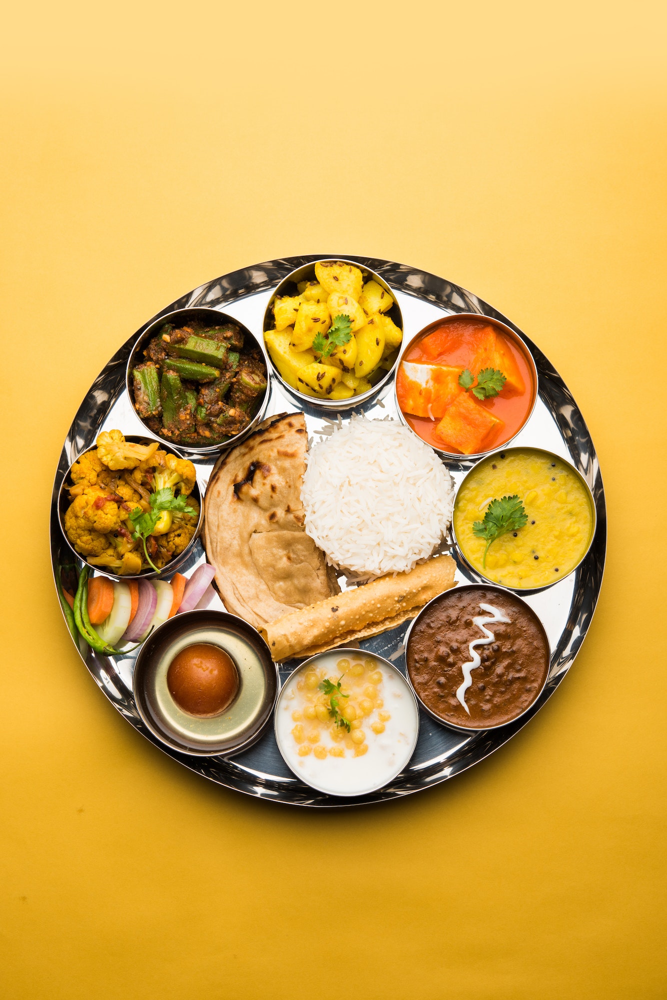 Indian assorted vegetarian food in plate and serving bowls