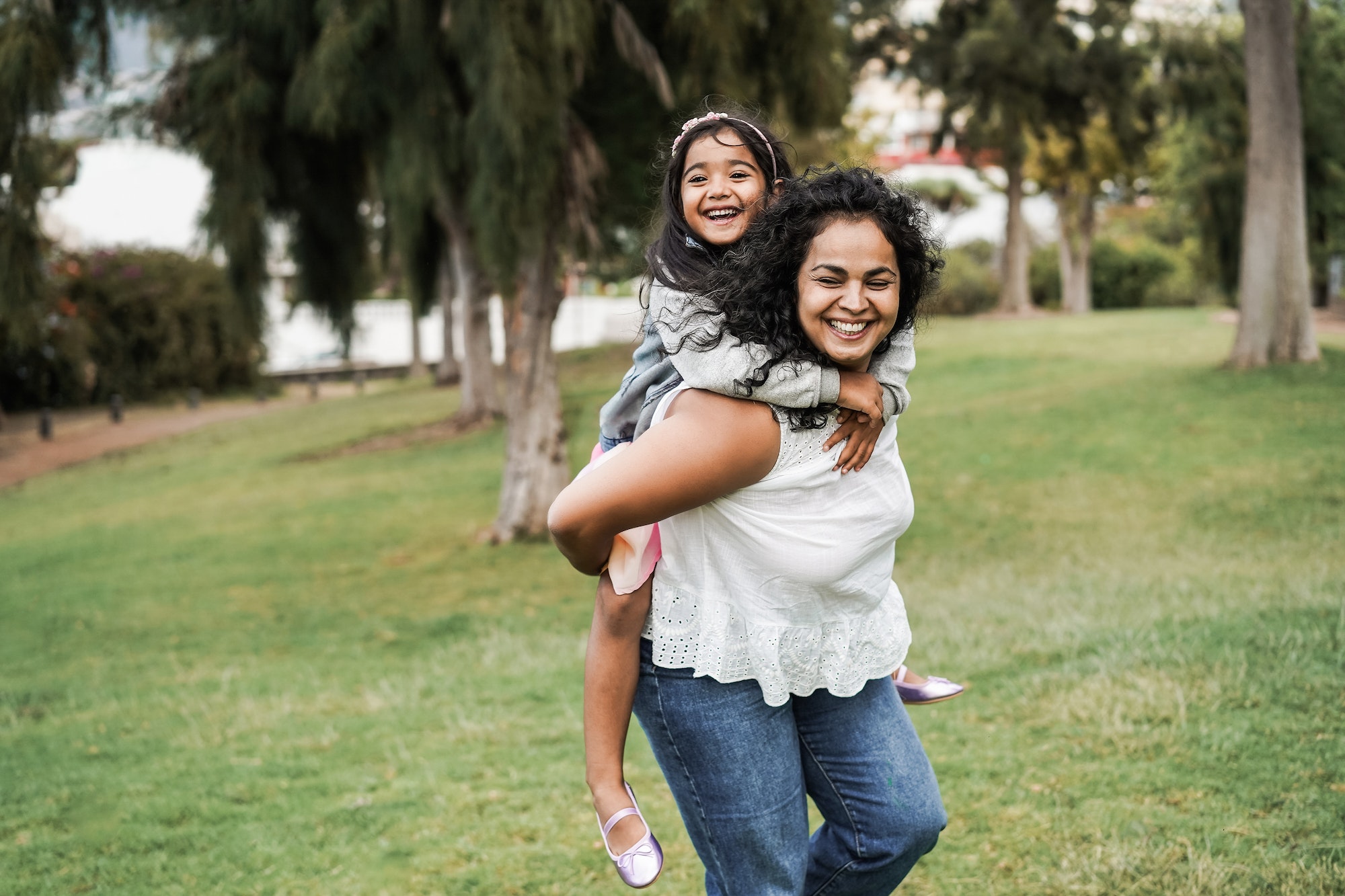 Happy indian mother having fun with her daughter outdoor - Focus on mother face