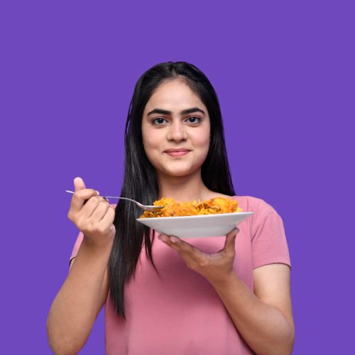 foodie-girl-holding-spoon-biryani-purple-background-indian-pakistani-model.jpg